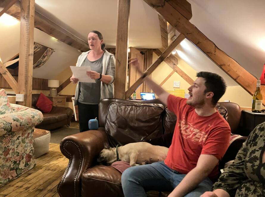 Practitioner and autistic adult engaged in conversation during a home-based PBS support session in a living room setting.